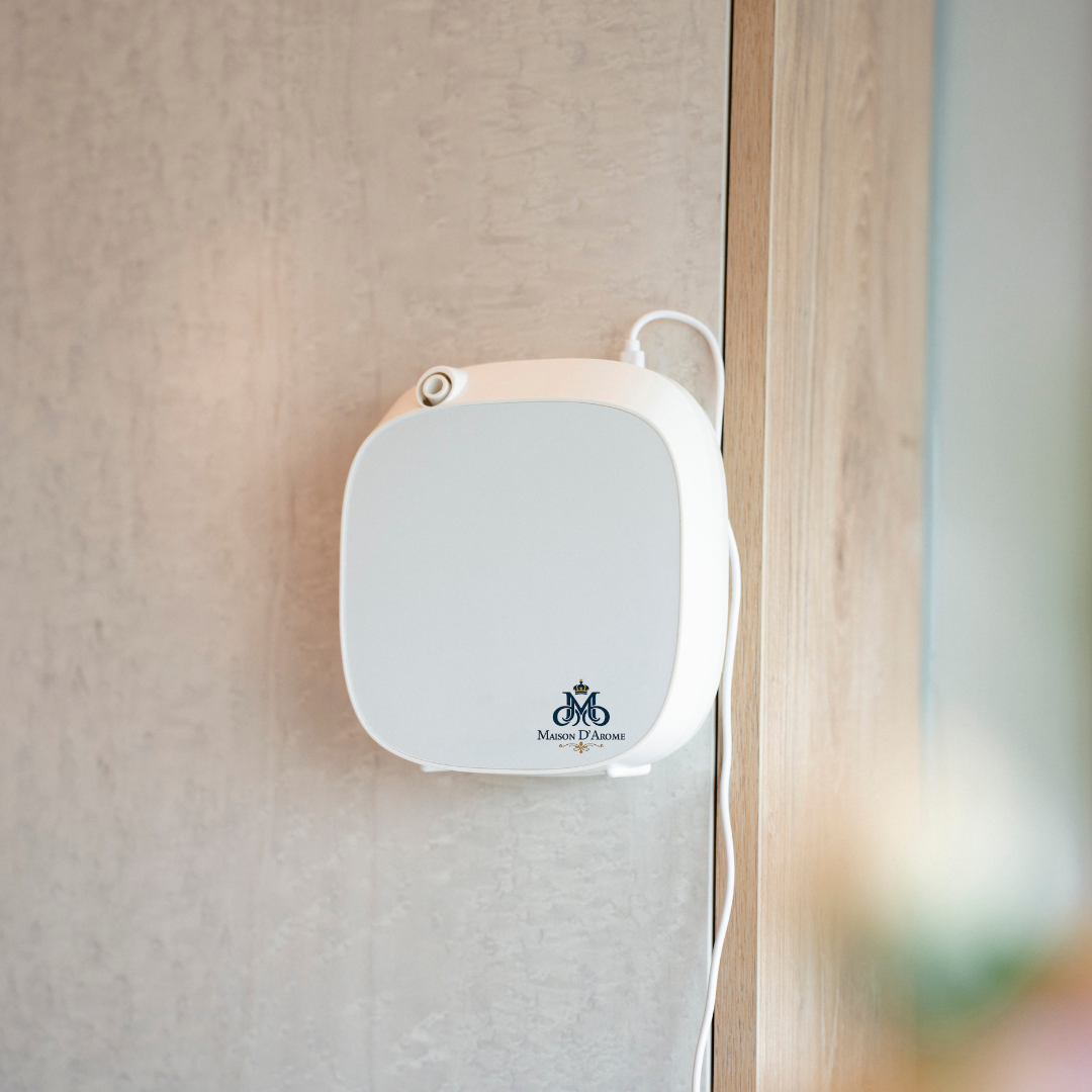 Difusor de Pared Inteligente A1-V3.1 instalado en la pared, ideal para baños, con estética minimalista.