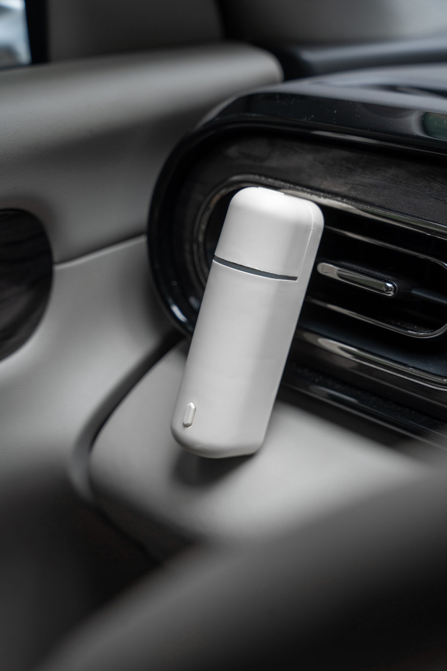 Difusor de aroma para auto A807-V2.0 montado en la salida de aire de un automóvil, destacando su diseño minimalista y moderno.