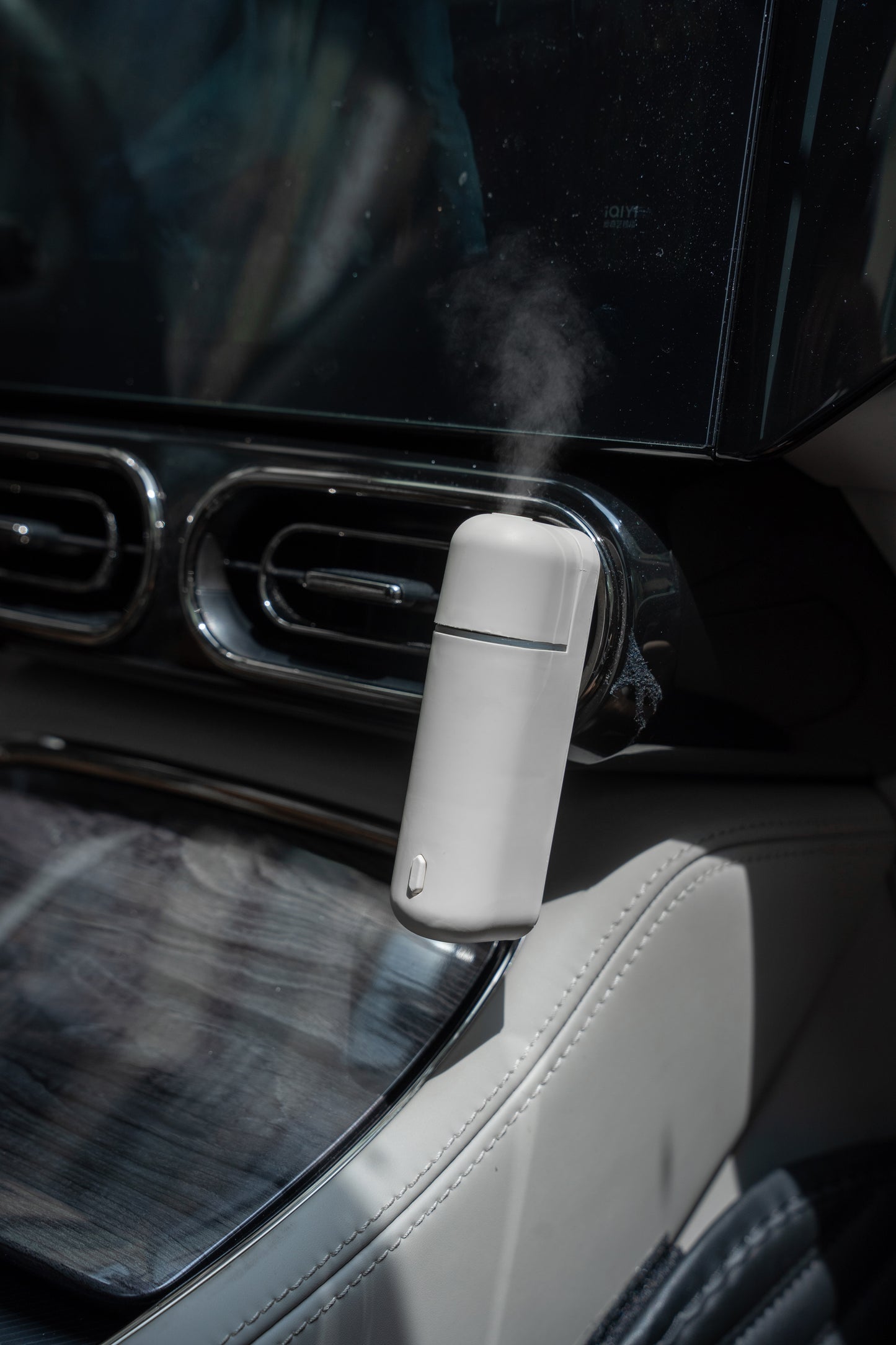 Difusor de aroma para auto A807-V2.0 colocado en el interior de un vehículo, emitiendo vapor para crear un ambiente fresco y elegante.