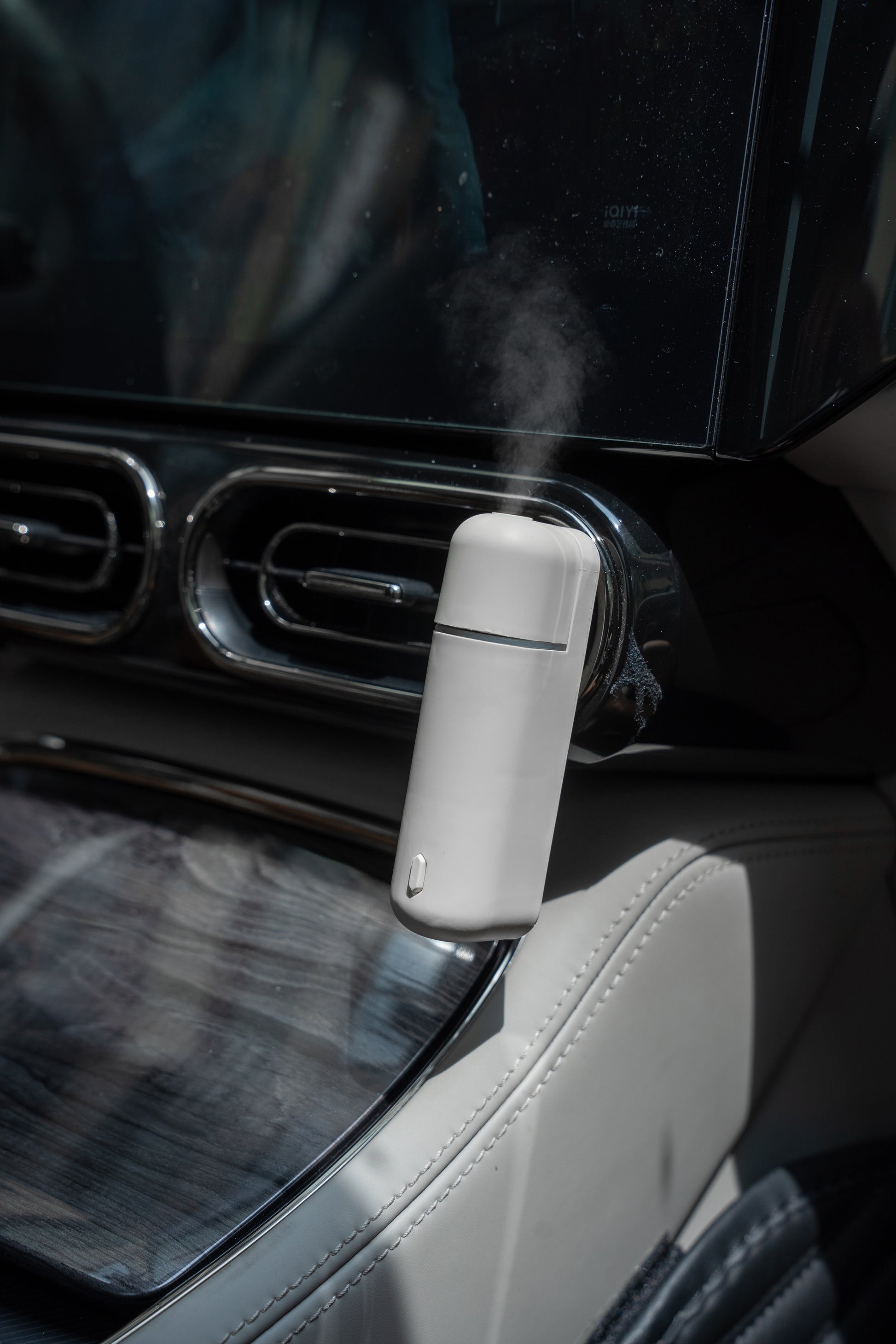 Difusor de aroma para auto A807-V2.0 colocado en el interior de un vehículo, emitiendo vapor para crear un ambiente fresco y elegante.